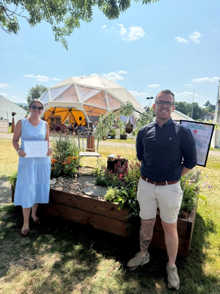 Katie and Liam of The Old Railway Line Garden Centre with their Gold medal-winning 'Gardening for Wellbeing' show garden at the Royal Welsh Show 2026.