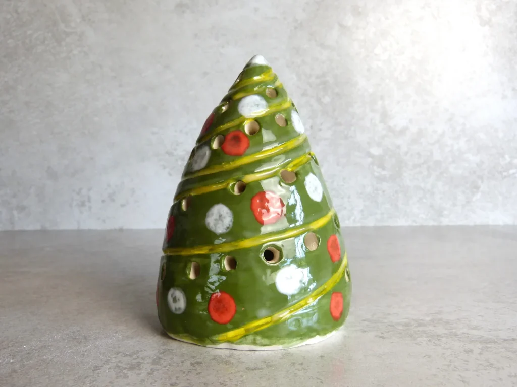 Handmade green ceramic Christmas tree lantern decorated with red and white baubles