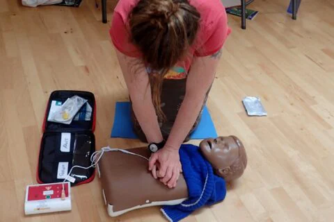 A trainee practising CPR on a manikin