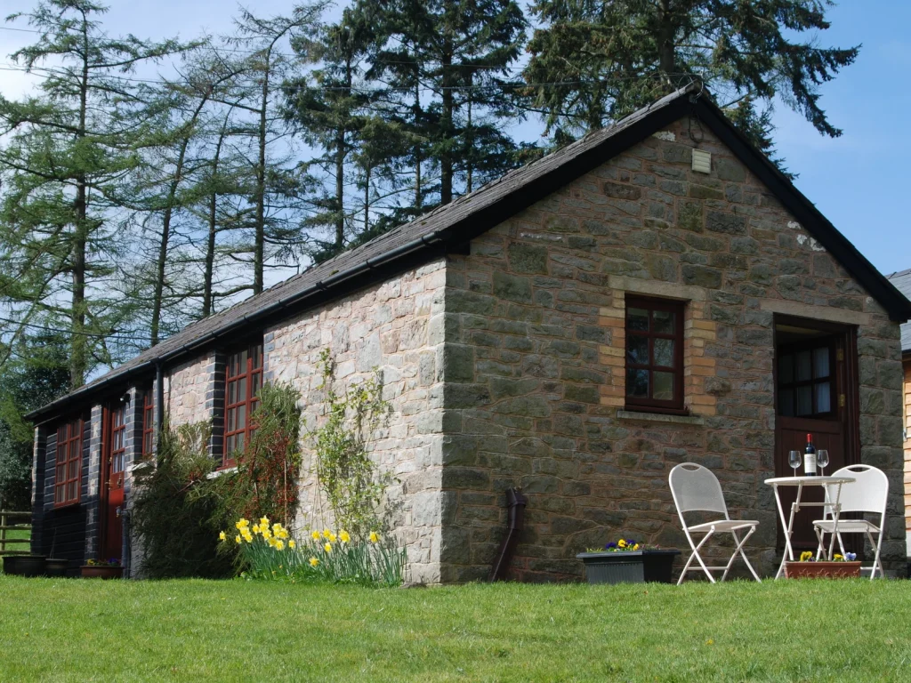 Stone exterior of Aberyscir Coach House with an outdoor table on the lawn