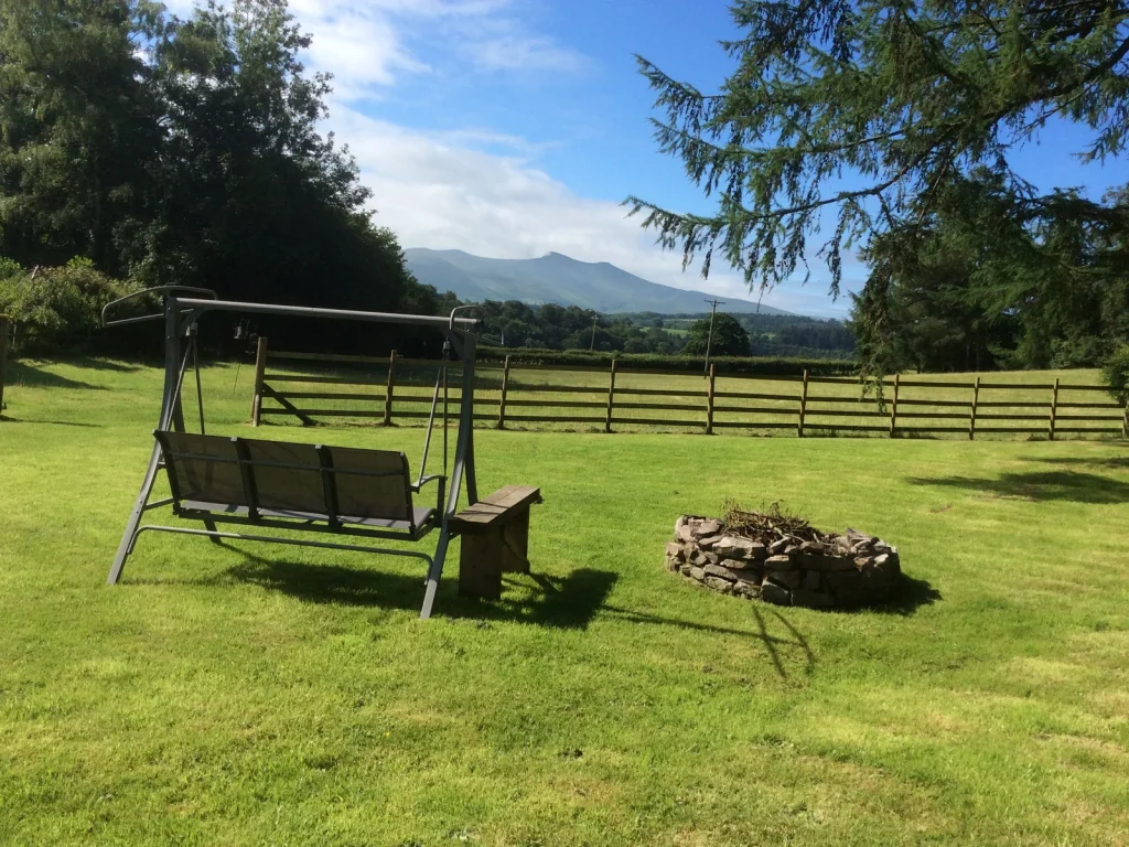Garden seating overlooking fields and mountains at Aberyscir Coach House