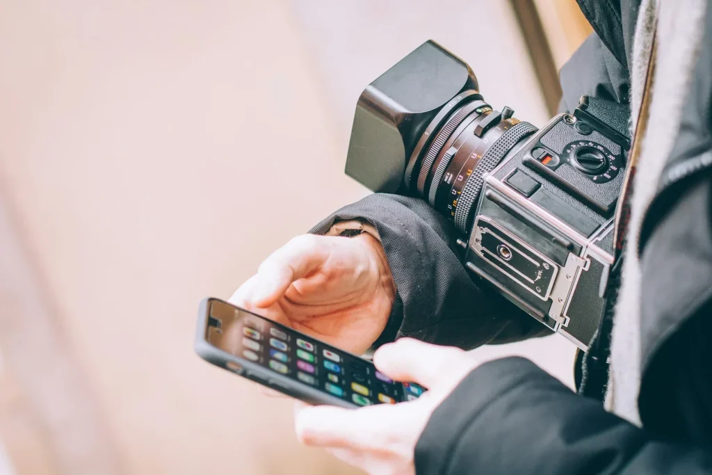 Content creator holding a camera and smartphone