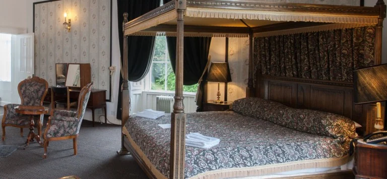 Four-poster bedroom with period furniture at Baskerville Hall Hotel