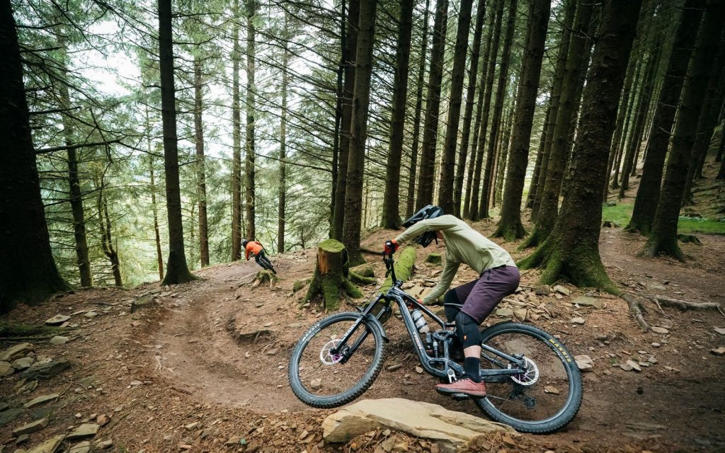 Mountain biker leaning through a technical forest section at BikePark Wales