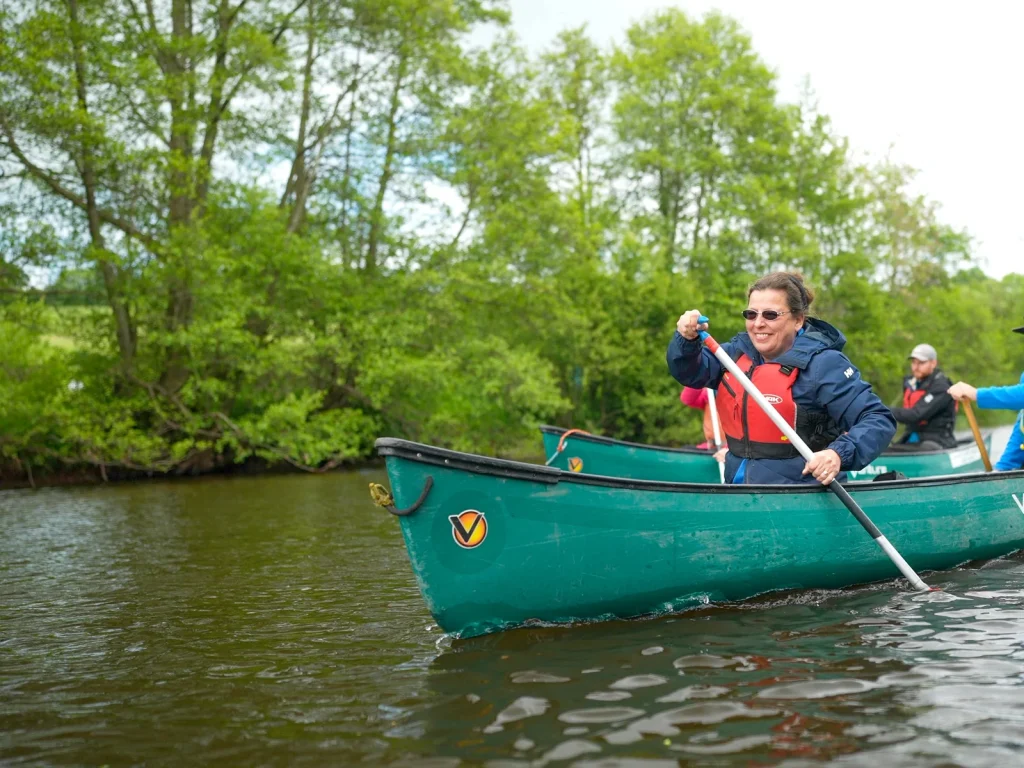 Two paddlers canoeing on the river with Black Mountain Adventure