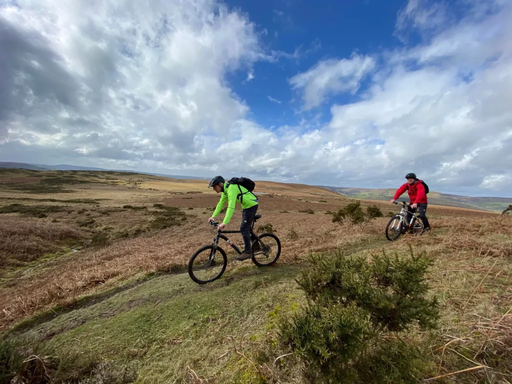 Mountain bikers crossing open moorland with Black Mountain Adventure