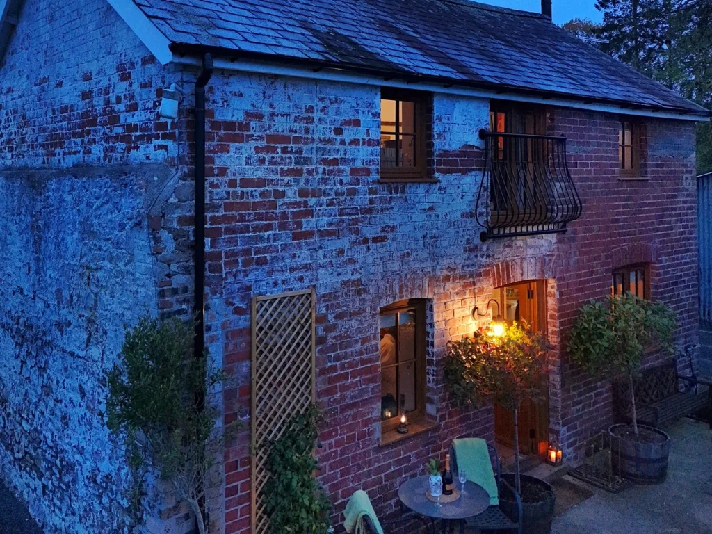 Gablebach cottage lit at dusk at Black Mountain Escapes near Llangadog