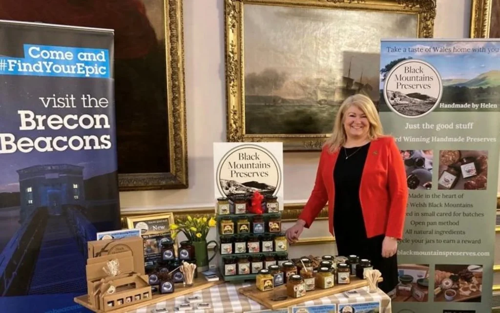 Helen beside a display of Black Mountains Preserves at a tourism event