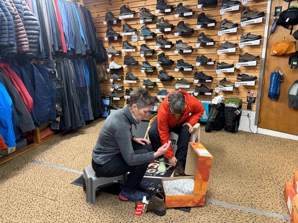 Staff member helping a customer fit walking boots at Crickhowell Adventure