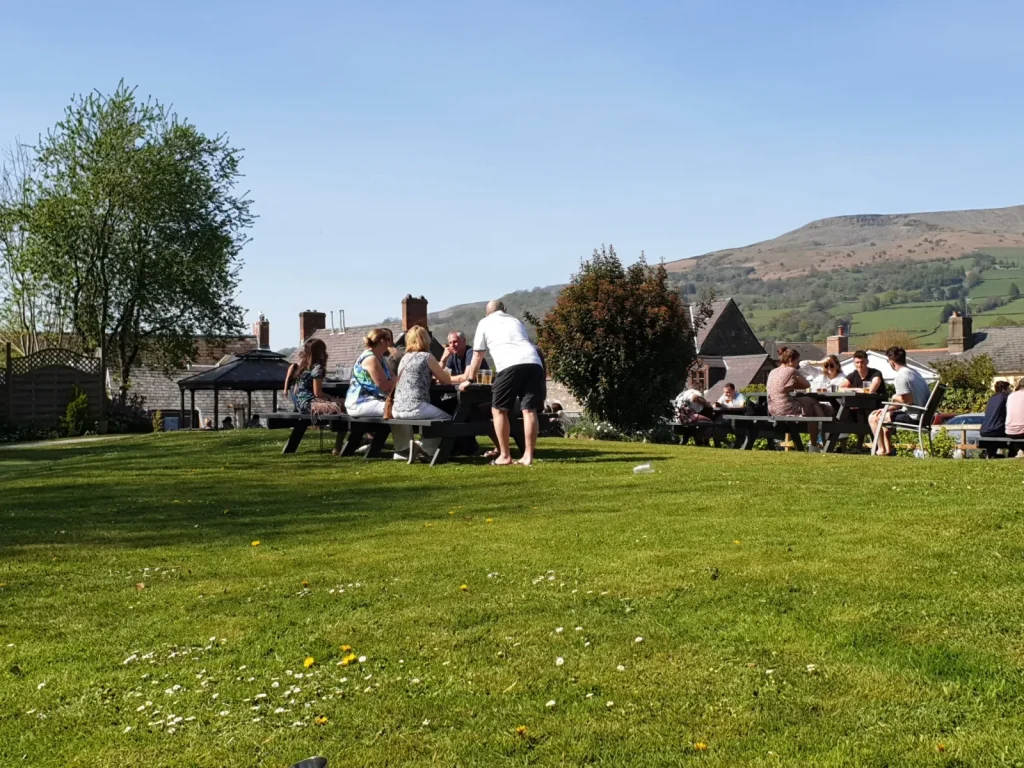 Guests relaxing in the large garden at the Dragon Inn in Crickhowell