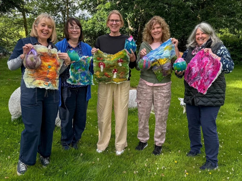 Fabulous Feltings participants displaying colourful handmade felt panels outdoors