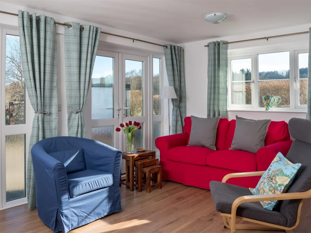 Bright lounge with red sofa inside Glanpant Bach cottage