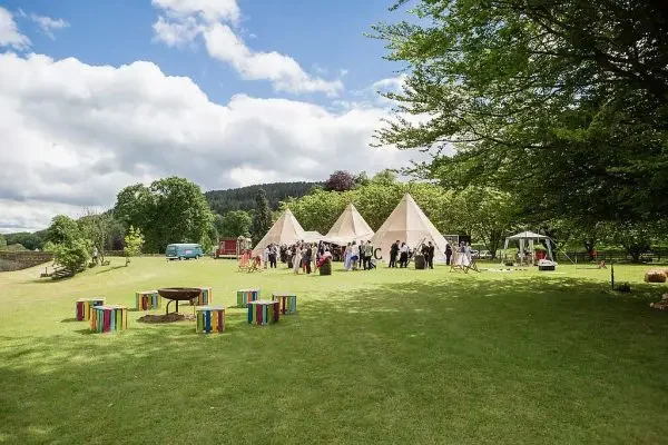 Tipis and outdoor seating arranged on an event lawn at Glanusk Estate