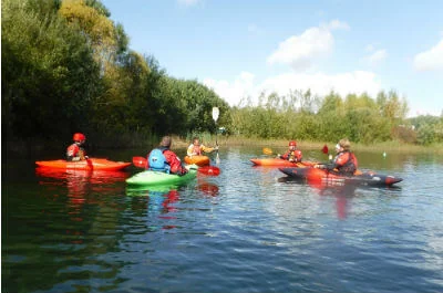 Group kayaking on calm water with Inspire2Adventure