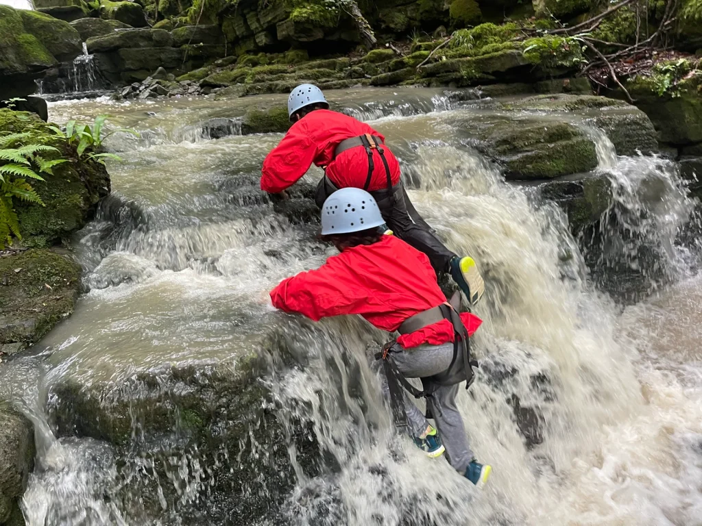Participant descending beside a waterfall with Inspire2Adventure