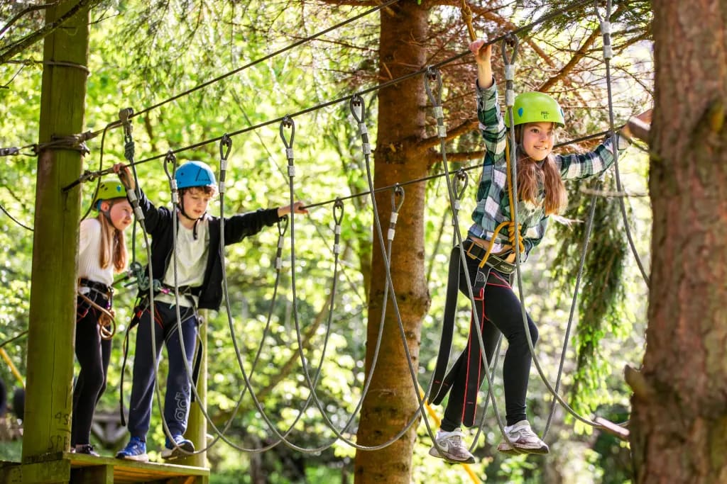 Young people wearing helmets on the high ropes course at Llangorse Multi Activity Centre
