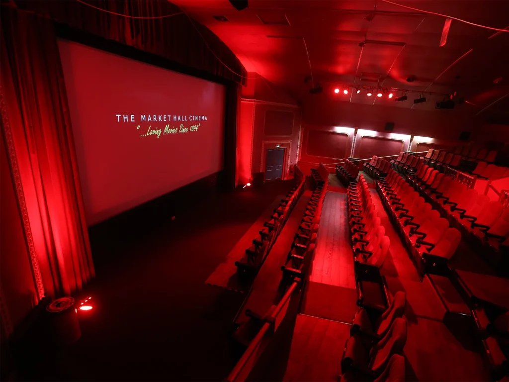 Red-lit auditorium and screen inside Market Hall Cinema