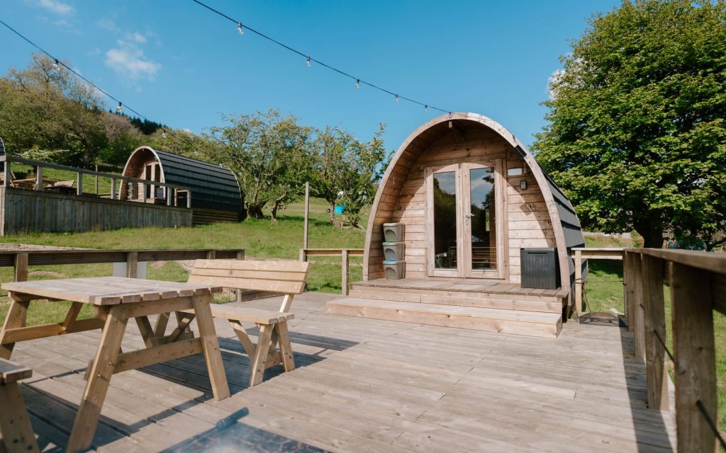 Timber glamping pod with outdoor seating overlooking the valley at Parkwood Outdoors Dolygaer
