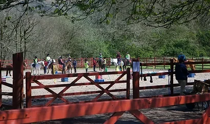 Group of riders crossing a wooded bridge on a guided trek from Pentre Riding Stables