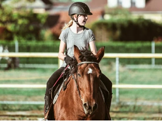 Young rider receiving support during an arena lesson at Pentre Riding Stables