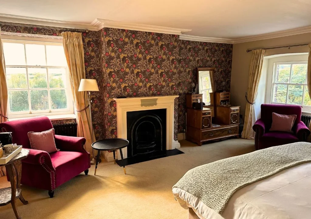 Individually styled bedroom with fireplace at Peterstone Court