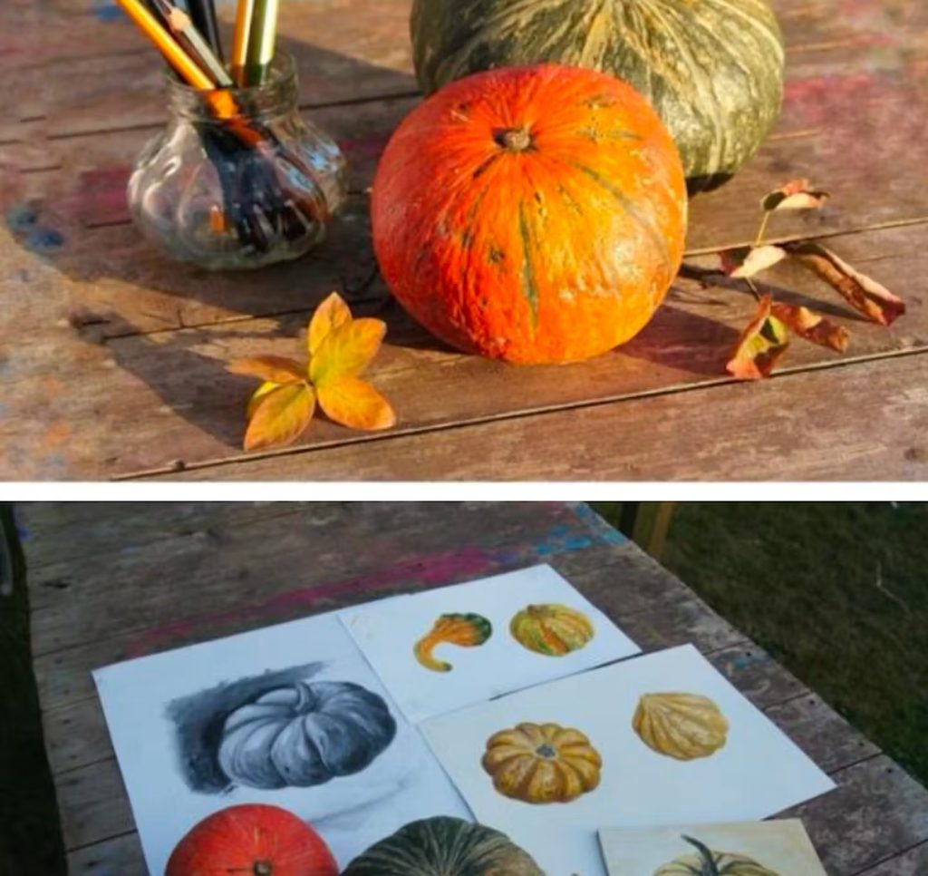 Pumpkins and gourds arranged beside artists’ drawings and painting materials