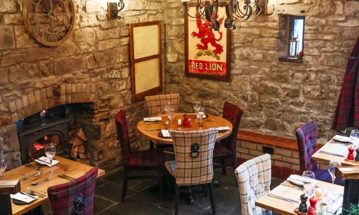 Stone-walled dining area with fireplace inside The Red Lion Penderyn