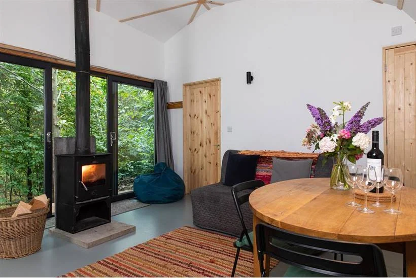 Warm living and dining space with a wood burner in a Sugar & Loaf hideaway