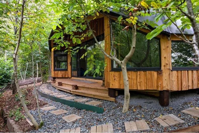 Small timber cabin tucked among trees in the Sugar & Loaf collection