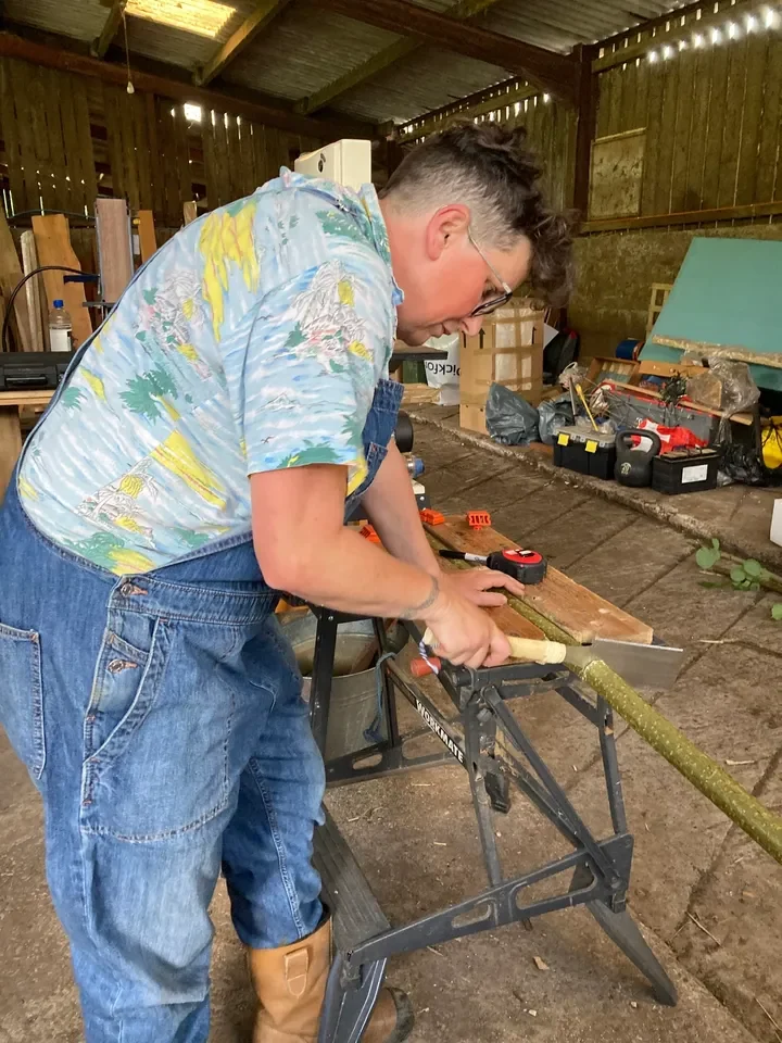 Participant using hand tools on timber inside the Toolbox Tan workshop