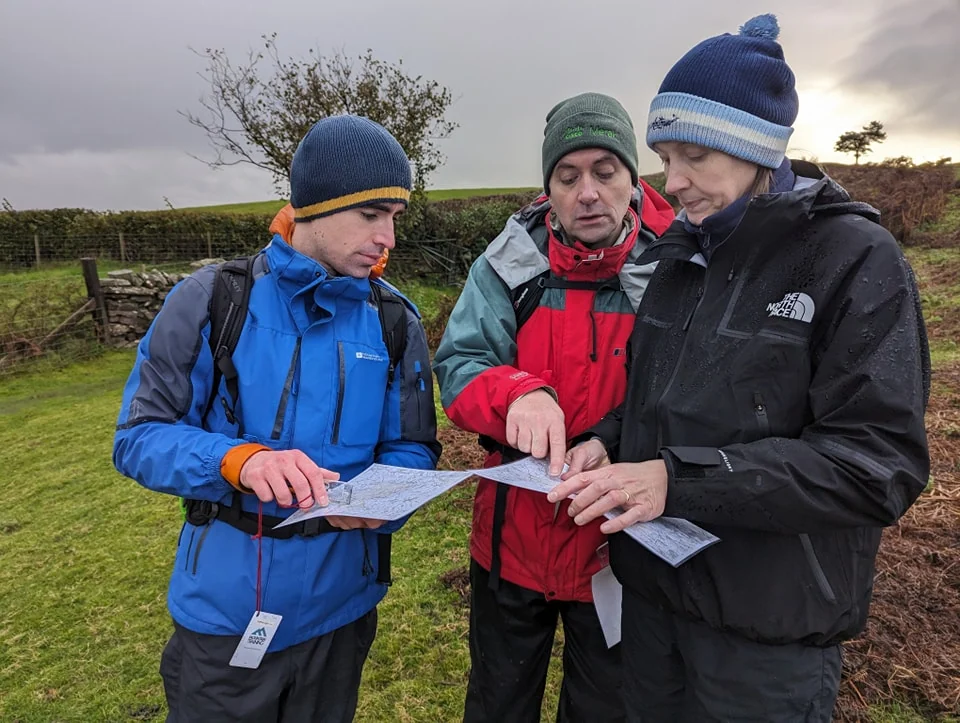 Walkers learning practical map and compass skills with Trig Point Adventures