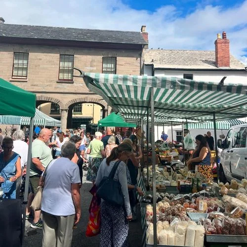 Visitors browsing independent market stalls in Hay-on-Wye