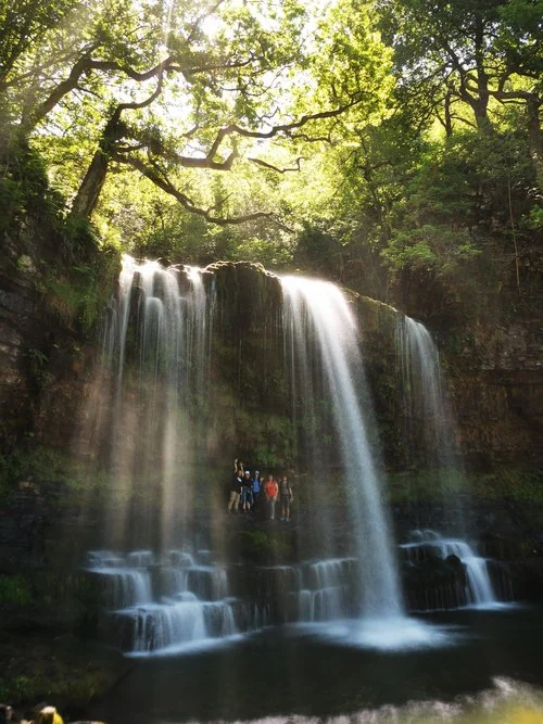 Waterfall in a green wooded valley explored with Wild Trails Wales