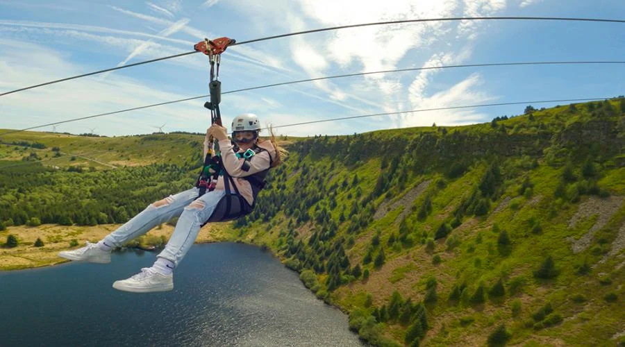 Visitor riding the Phoenix zip line above the landscape at Zip World Tower Colliery