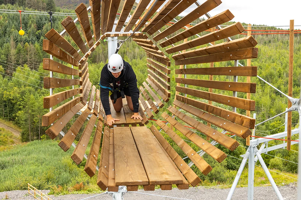 Visitor tackling a suspended obstacle on the Tower Climber course at Zip World